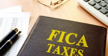 FICA Taxes and calculator on a table.