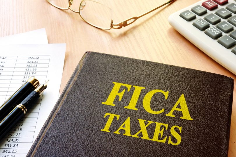 FICA Taxes and calculator on a table.